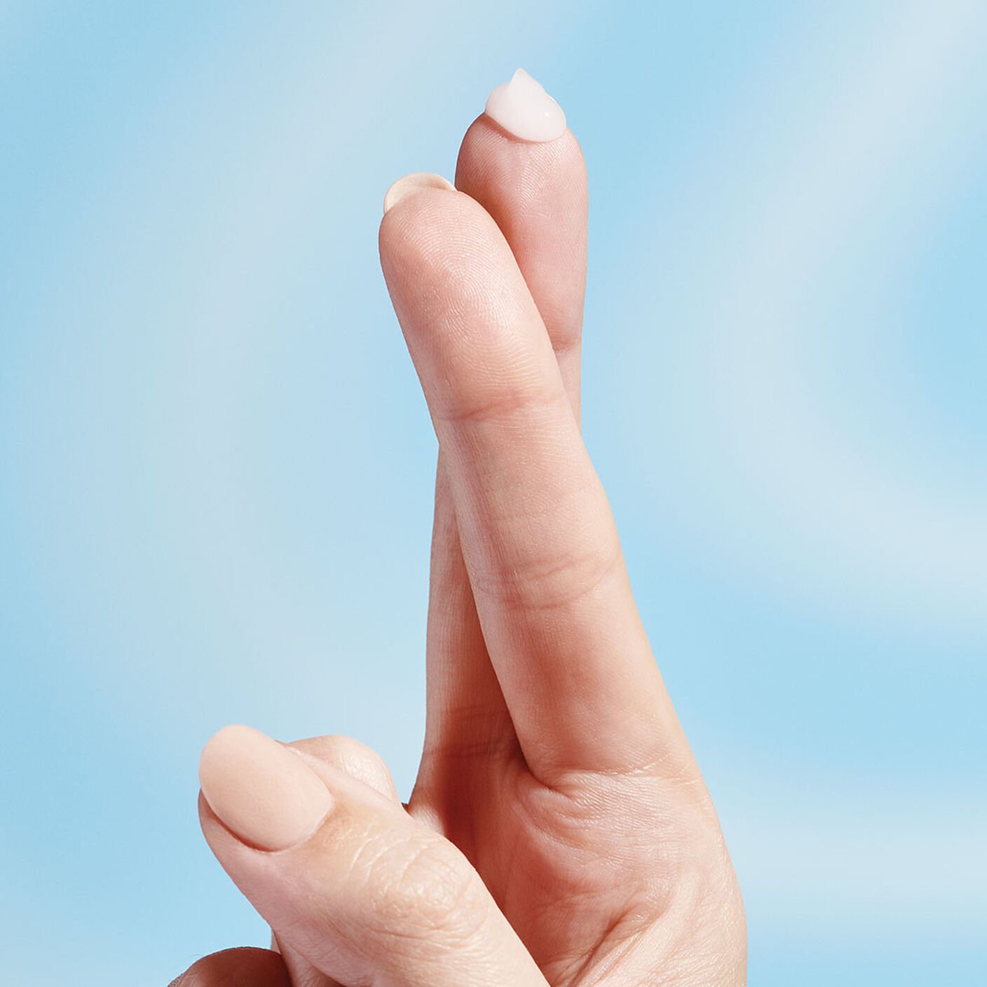 A drop of B-Hydra serum sitting on the top of the finger tip. 